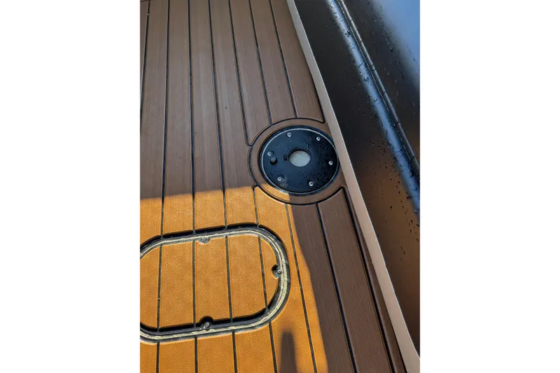 Slide: The Image of SeaArk Big Easy 2026 boat deck with wood finish and circular hatch detail. - 29