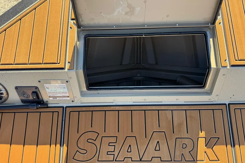 Slide: The Image of 2026 SeaArk Big Easy boat deck with open storage compartment and wood-like flooring. - 9