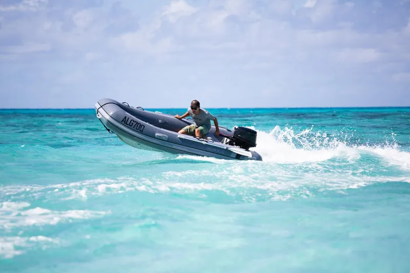 Slide: The Image of Man driving 2026 Highfield Classic 310 inflatable boat on turquoise water. - 10