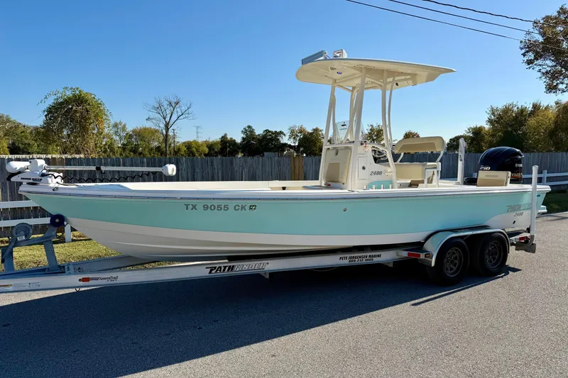 Slide: The Image of 2014 Pathfinder 2400 TRS boat on trailer, light blue hull, parked outdoors. - 1