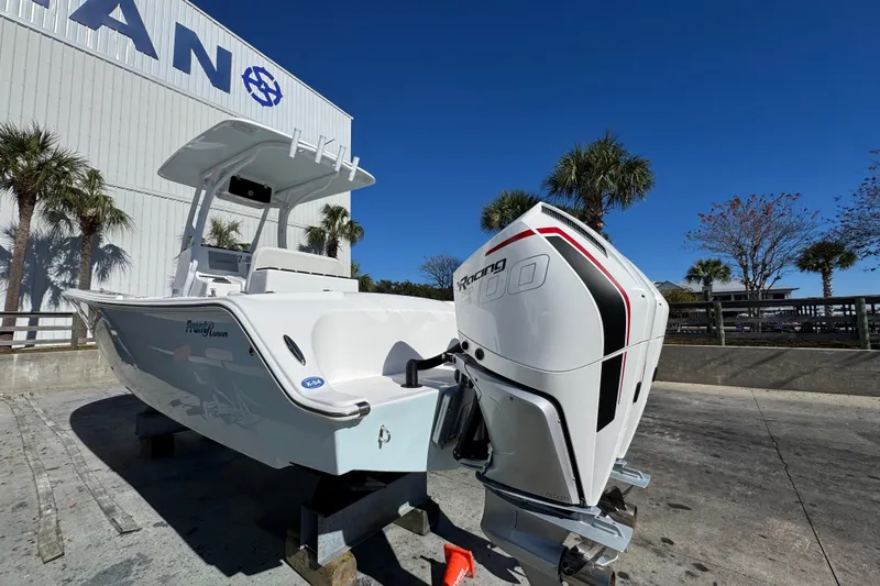 Slide: The Image of 2022 Front Runner 26 Center Console boat with powerful outboard motor, docked outdoors. - 11