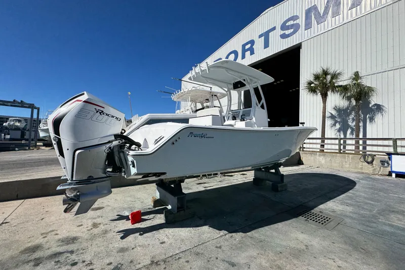 Slide: The Image of 2022 Front Runner 26 Center Console boat with powerful outboard engine, docked near a marina. - 15