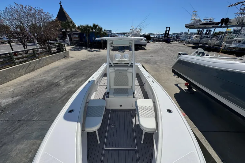 Slide: The Image of 2022 Front Runner 26 Center Console boat docked at a marina under clear blue skies. - 21