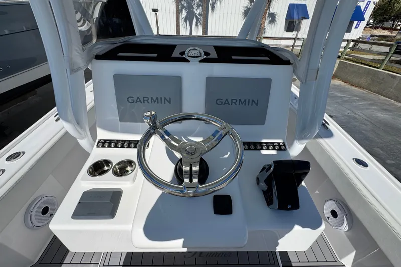 Slide: The Image of 2022 Front Runner 26 Center Console boat dashboard with Garmin displays and steering wheel. - 29