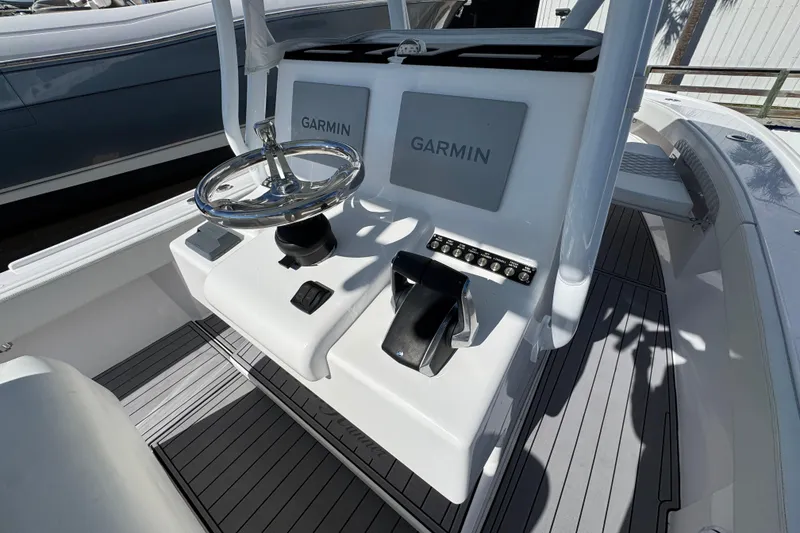 Slide: The Image of 2022 Front Runner 26 Center Console boat with Garmin navigation system and sleek steering wheel. - 31