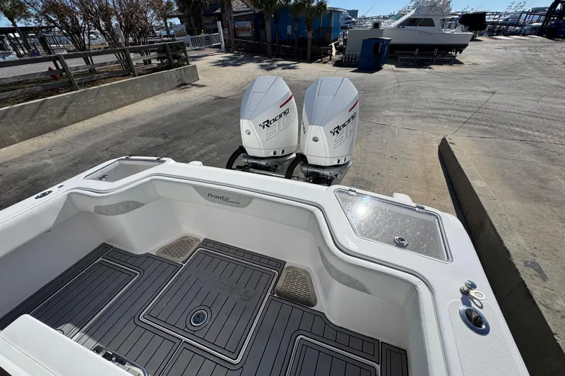 Slide: The Image of 2022 Front Runner 26 Center Console boat with twin outboard engines at a marina. - 36