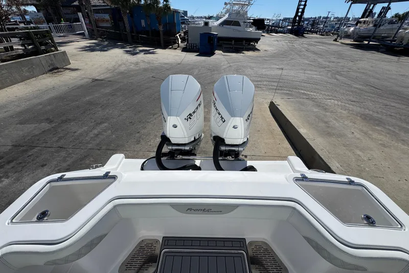 Slide: The Image of 2022 Front Runner 26 Center Console boat with twin outboard engines at a marina. - 37