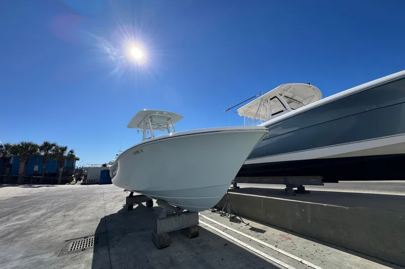 Slide: The Image of 2022 Front Runner 26 Center Console boat under bright sun on a dock. - 5