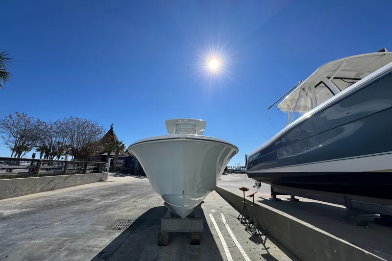 Slide: The Image of 2022 Front Runner 26 Center Console boat under bright sun in marina setting. - 7
