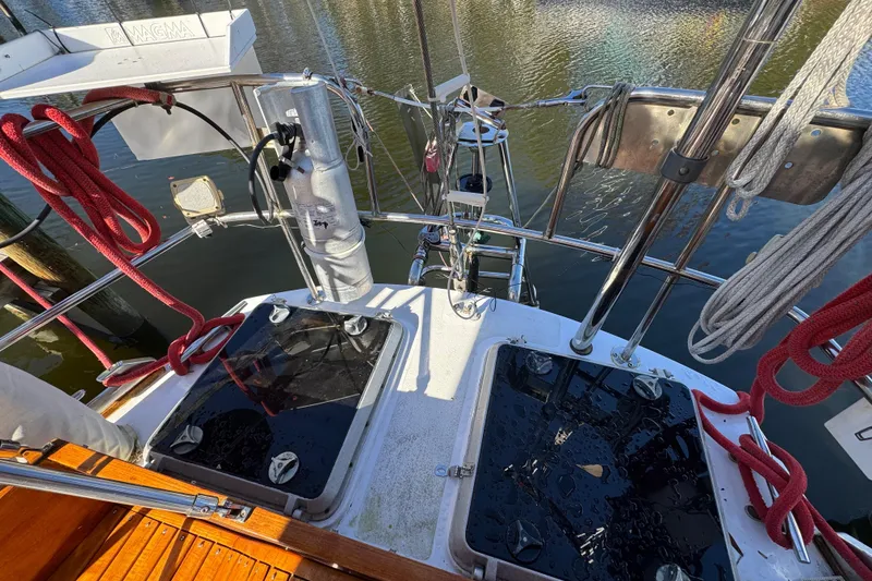 Slide: The Image of 1997 Creekmore Cutter sailboat deck with ropes and equipment by the water. - 10