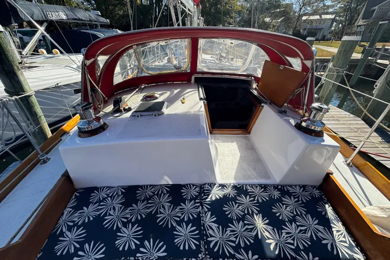 Slide: The Image of Cockpit of 1997 Creekmore Cutter sailboat with floral cushions and red canopy. - 14