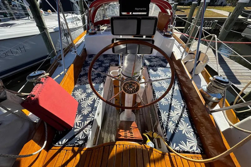 Slide: The Image of Cockpit of 1997 Creekmore Cutter sailboat with wooden wheel and floral-patterned seating. - 15