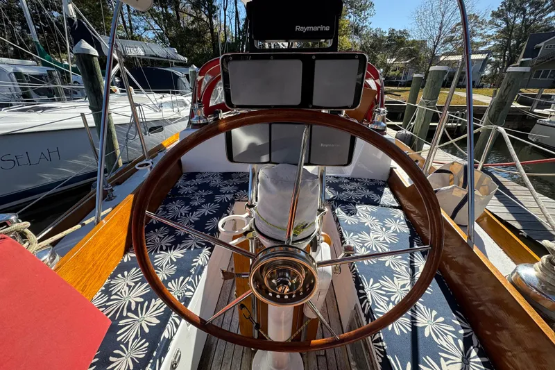 Slide: The Image of Cockpit of 1997 Creekmore Cutter sailboat with wooden steering wheel and nautical decor. - 16