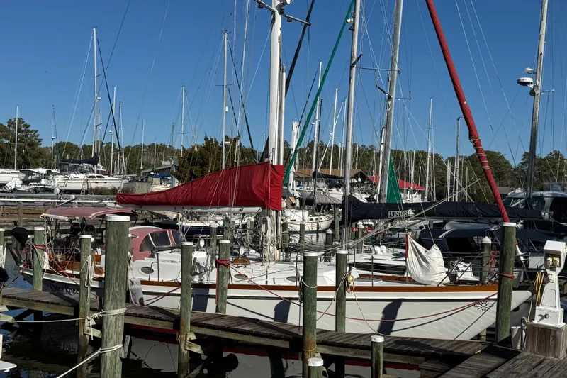 Slide: The Image of Sailboats docked at marina, featuring a 1997 Creekmore Cutter under clear blue skies. - 19