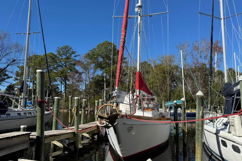 Slide: The Image of Sailboat docked at marina, Creekmore Cutter 1997, surrounded by trees and clear blue sky. - 2