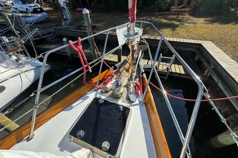 Slide: The Image of Bow of 1997 Creekmore Cutter sailboat docked, featuring deck equipment and railing. - 22