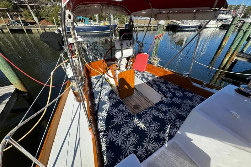 Slide: The Image of Creekmore Cutter 1997 sailboat with floral-patterned deck, docked at a marina. - 26