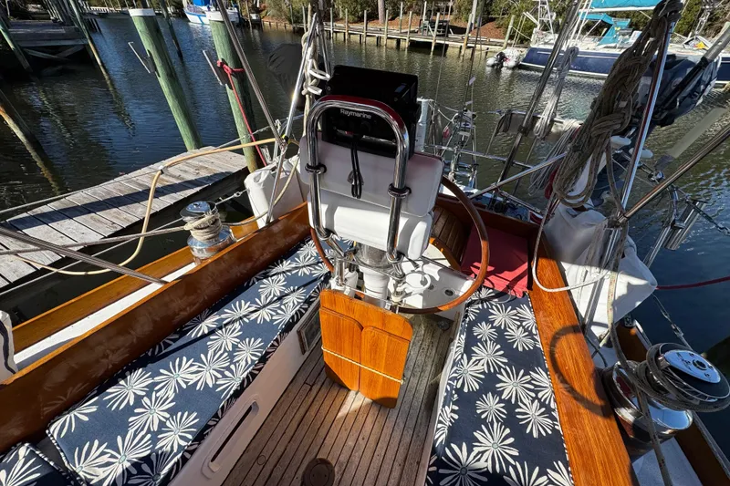 Slide: The Image of Cockpit of 1997 Creekmore Cutter sailboat with floral cushions and wooden accents. - 31