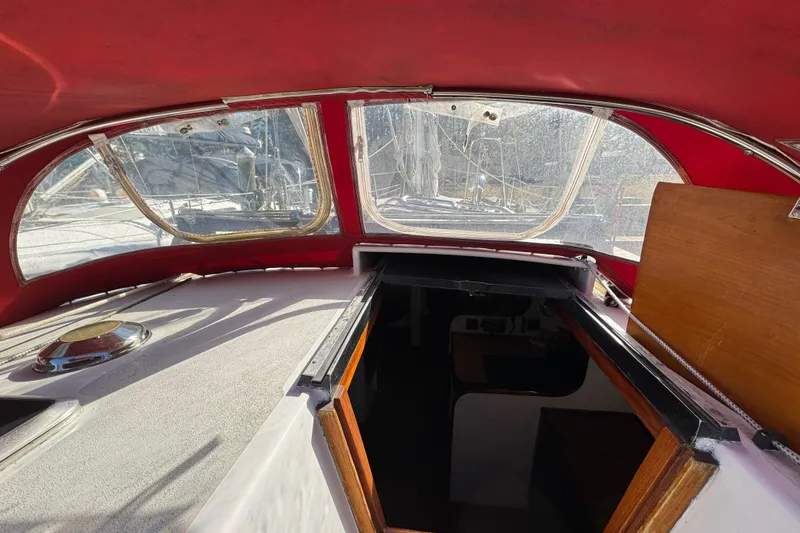 Slide: The Image of Interior view of a 1997 Creekmore Cutter sailboat with red canopy and open hatch. - 37