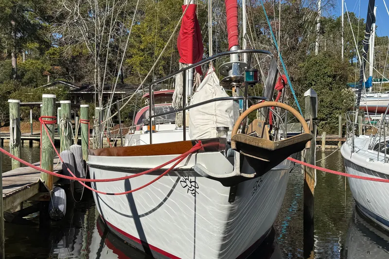 Slide: The Image of Sailboat docked at marina, Creekmore Cutter 1997, with red sails and wooden wheel. - 4