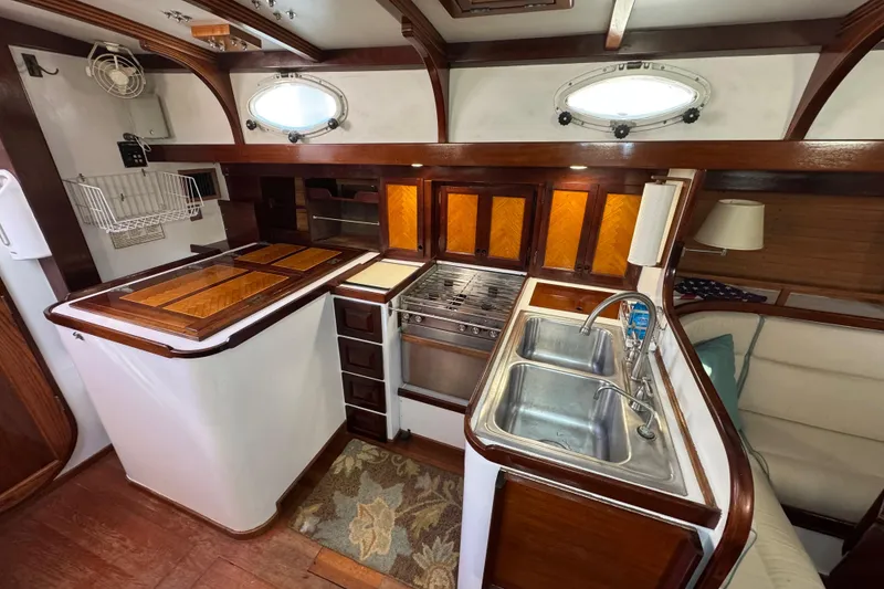 Slide: The Image of Interior of 1997 Creekmore Cutter yacht kitchen with wood accents and dual sinks. - 42