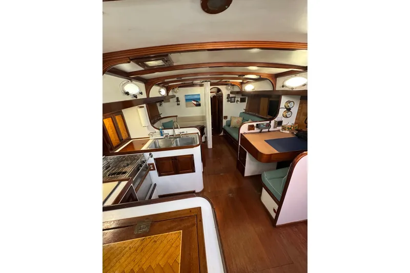 Slide: The Image of Interior of 1997 Creekmore Cutter sailboat with wood accents and cozy seating area. - 56