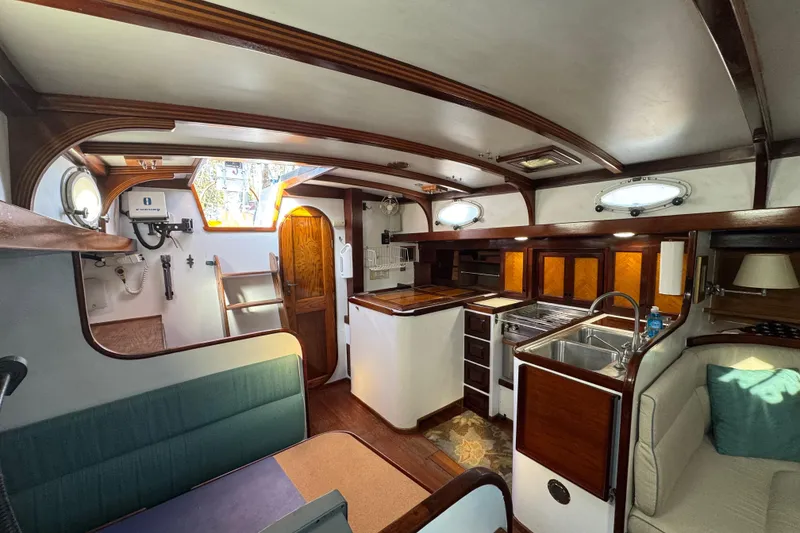 Slide: The Image of Interior of a 1997 Creekmore Cutter sailboat with wood accents and compact kitchen. - 59