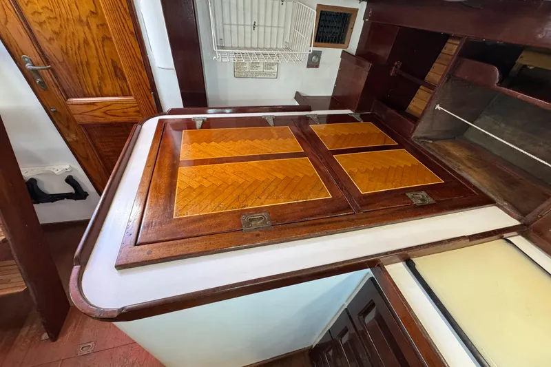 Slide: The Image of Interior of a 1997 Creekmore Cutter sailboat with wooden cabinetry and storage compartments. - 65