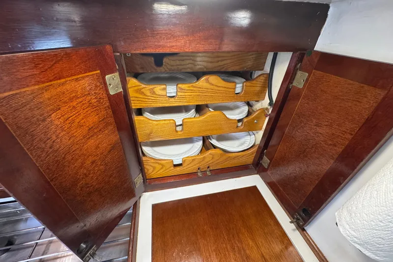 Slide: The Image of Wooden cabinet with organized plate storage on a 1997 Creekmore Cutter boat. - 73