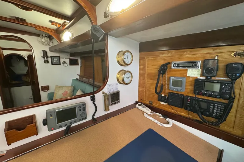 Slide: The Image of Navigation station inside a 1997 Creekmore Cutter sailboat, featuring communication and navigation equipment. - 82
