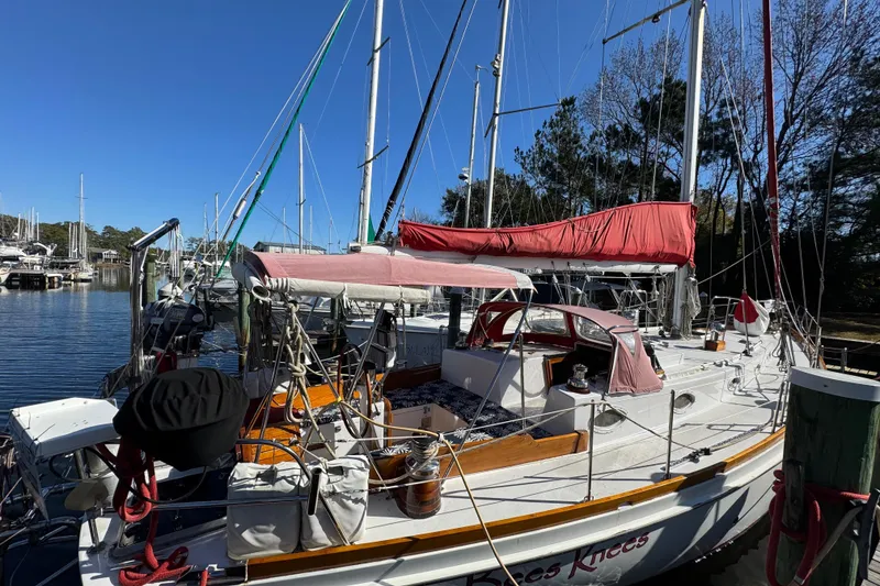 Slide: The Image of Sailboat docked at marina, Creekmore Cutter 1997, with red sail cover and clear blue sky. - 9