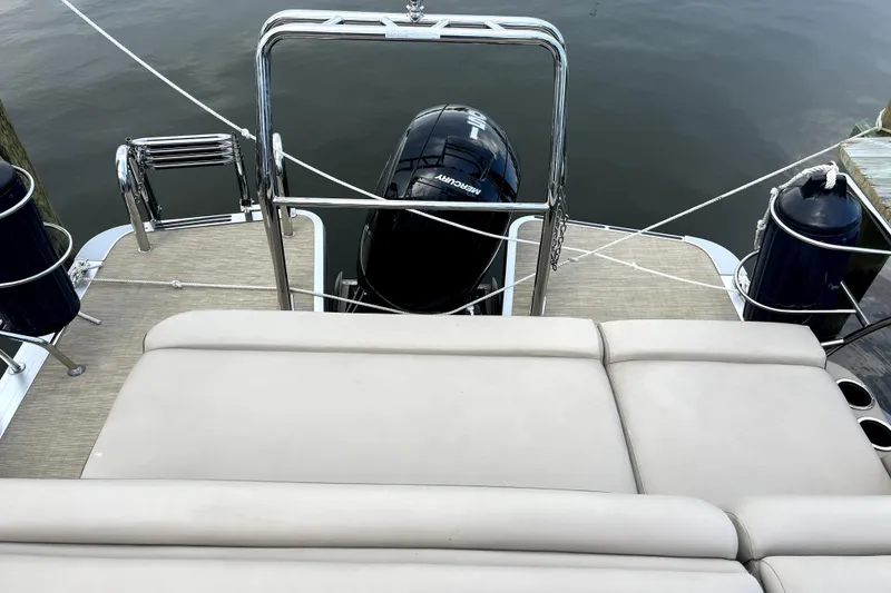 Slide: The Image of 2024 Harris HCX23 boat with Mercury engine, viewed from the deck, docked at a marina. - 9