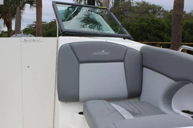 Slide: The Image of 2023 NauticStar 243 DC Deck boat interior with gray seating and windshield. - 15