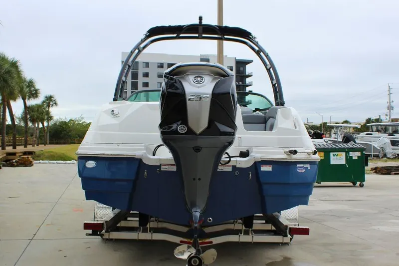 Slide: The Image of 2023 NauticStar 243 DC Deck boat on trailer, rear view with outboard motor. - 3
