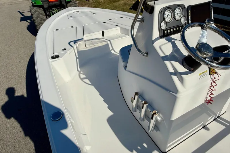 Slide: The Image of 2014 Sportsman Tournament 214 Bay Boat with steering console and gauges, parked on pavement. - 12