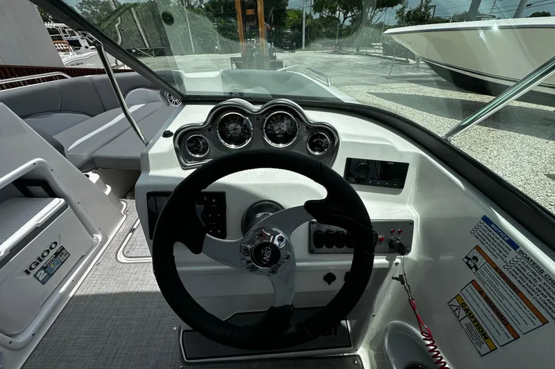 Slide: The Image of 2024 NauticStar 203 DC Deck boat dashboard with steering wheel and gauges. - 10