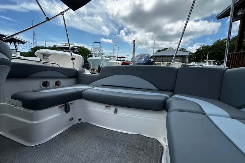 Slide: The Image of 2024 NauticStar 203 DC Deck boat interior with gray seating and open sky view. - 14
