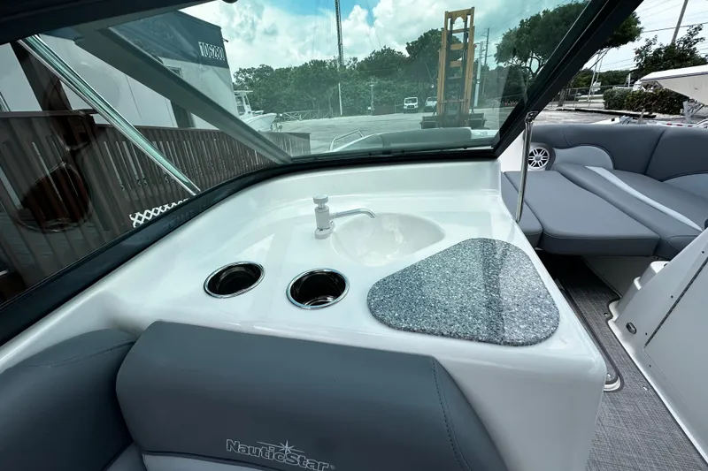 Slide: The Image of 2024 NauticStar 203 DC Deck boat interior with sink and seating area. - 16