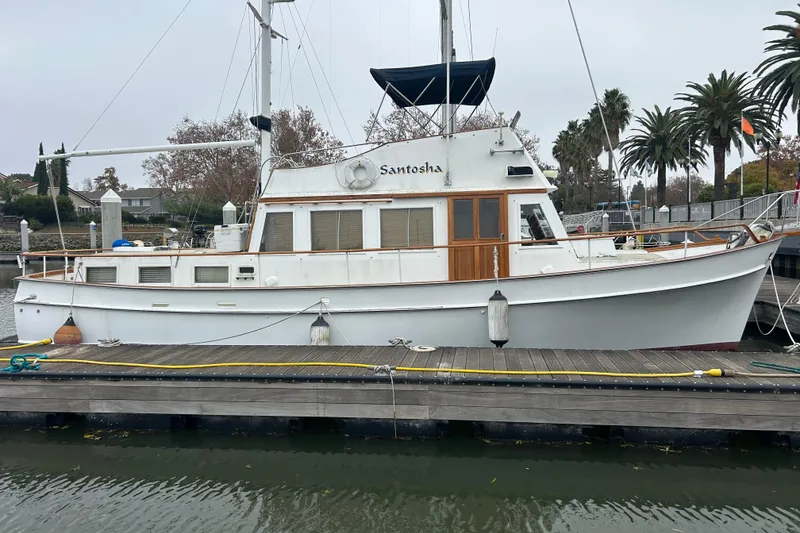The Image of 1976 Bristol Trawler docked at marina, surrounded by palm trees and calm water. - 0