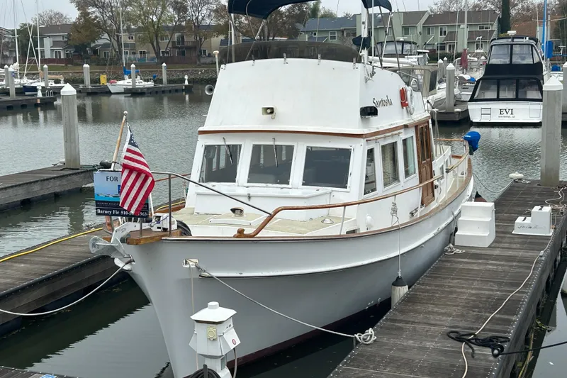 Slide: The Image of 1976 Bristol Trawler docked at marina, displaying American flag, with "For Sale" sign. - 1