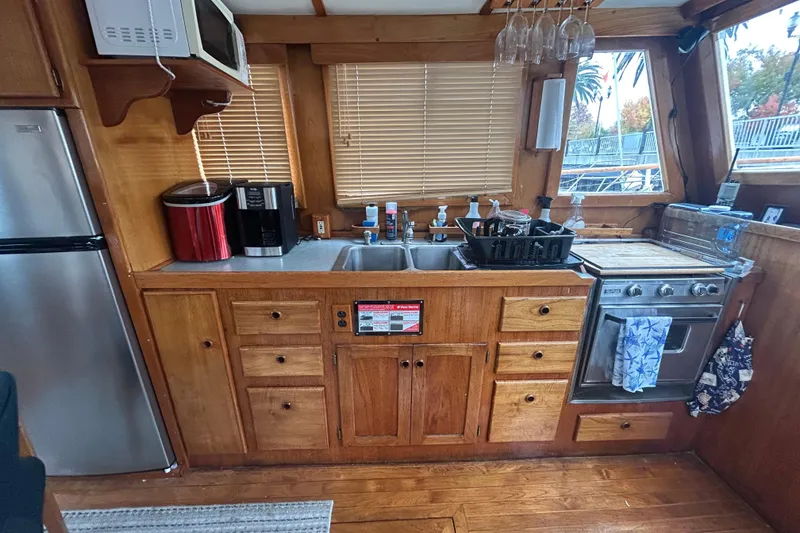 Slide: The Image of 1976 Bristol Trawler kitchen with wooden cabinets, stainless steel appliances, and a cozy nautical design. - 11