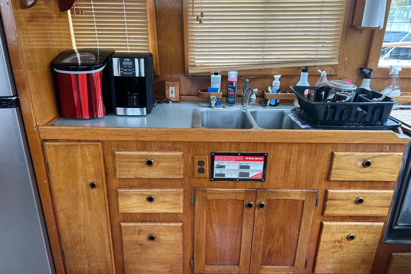 Slide: The Image of 1976 Bristol Trawler kitchen with wooden cabinets, sink, and appliances. - 12