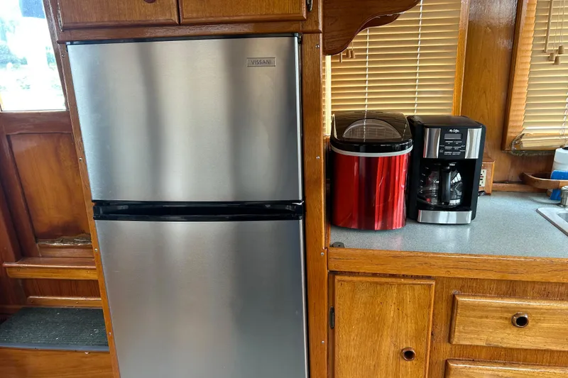 Slide: The Image of 1976 Bristol Trawler kitchen with stainless steel fridge, red ice maker, and coffee machine. - 14