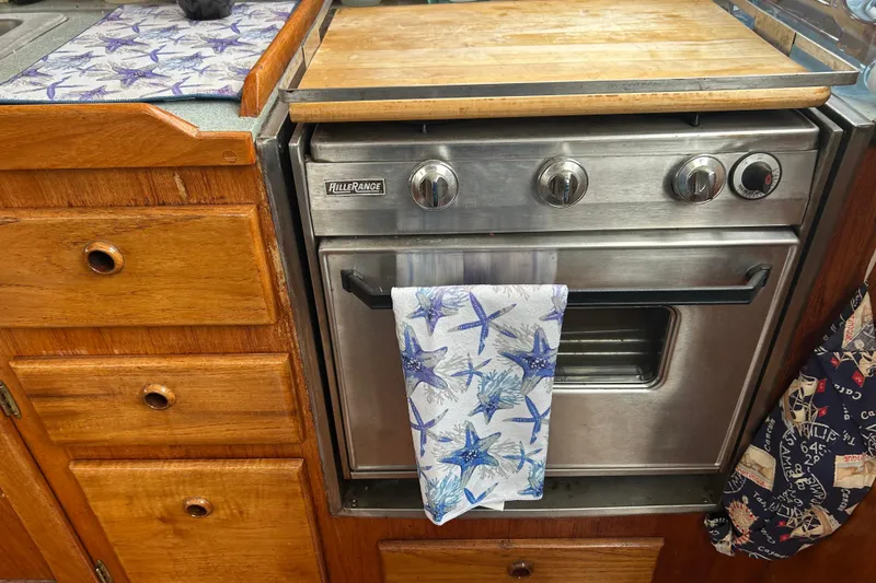 Slide: The Image of 1976 Bristol Trawler kitchen with wooden cabinets and a stainless steel oven. - 15