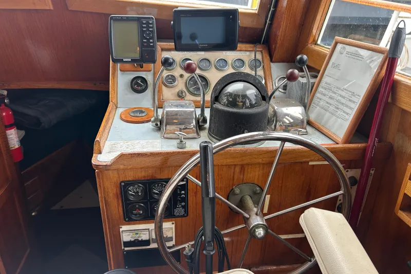 Slide: The Image of 1976 Bristol Trawler helm with vintage controls, steering wheel, and navigation equipment. - 19
