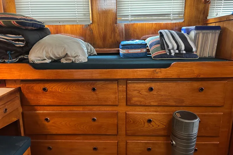 Slide: The Image of 1976 Bristol Trawler interior with wooden drawers, bedding, and storage containers. - 30