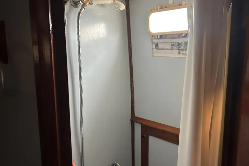 Slide: The Image of 1976 Bristol Trawler shower area with curtain and porthole window. - 33