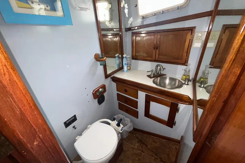 Slide: The Image of 1976 Bristol Trawler bathroom with wooden cabinets, sink, and toilet. - 38
