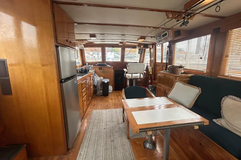 Slide: The Image of 1976 Bristol Trawler interior with wooden decor, kitchen, seating, and helm station. - 4