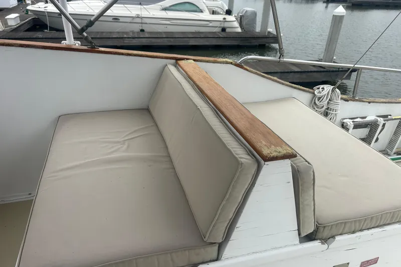 Slide: The Image of 1976 Bristol Trawler boat with cushioned seating, docked at a marina. - 44